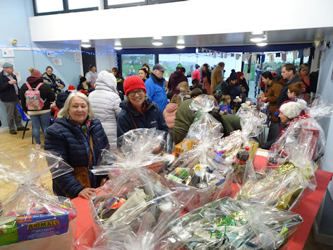 Pam Stacey and Wendy Roberts with the raffle prizes at the Trumpington Pavilion Christmas Fair. Photo: Andrew Roberts, 4 December 2022.